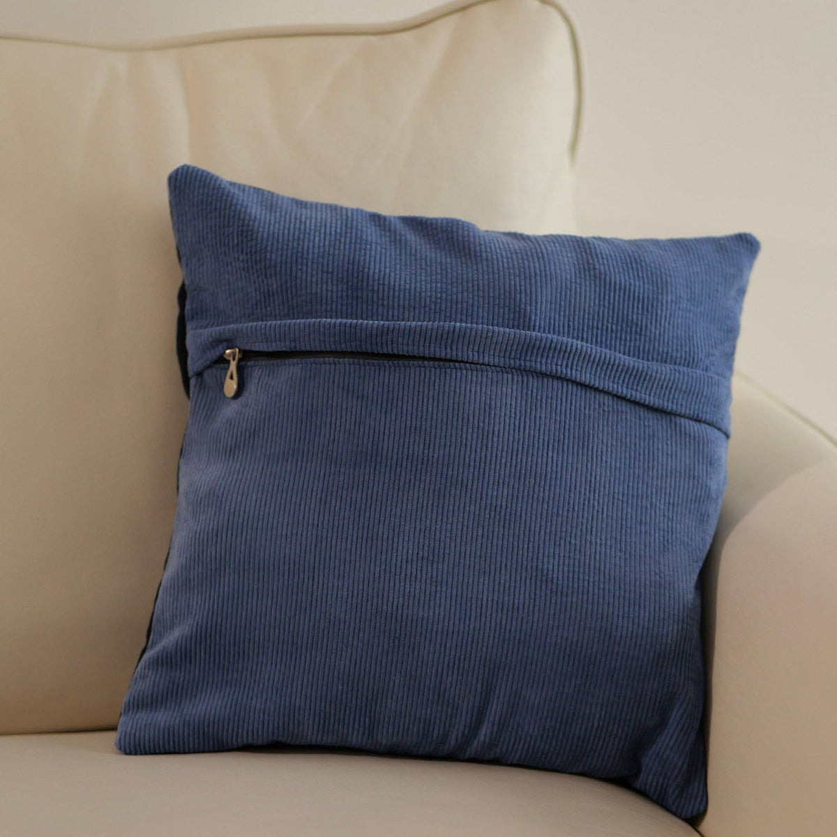Blue pillow cover with exposed zipper along the top edge