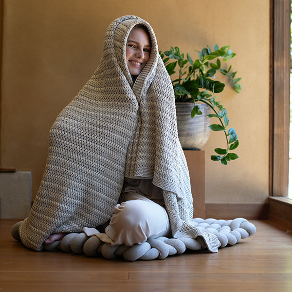 Heather gray knit throw blanket draped in a hooded shape