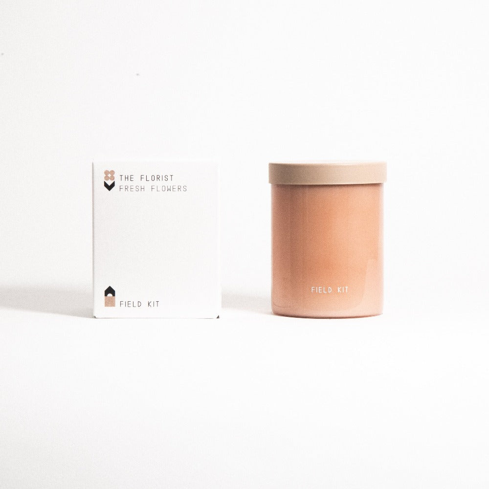 Florist candle with amber jar and tan lid beside 'FIELD KIT' box
