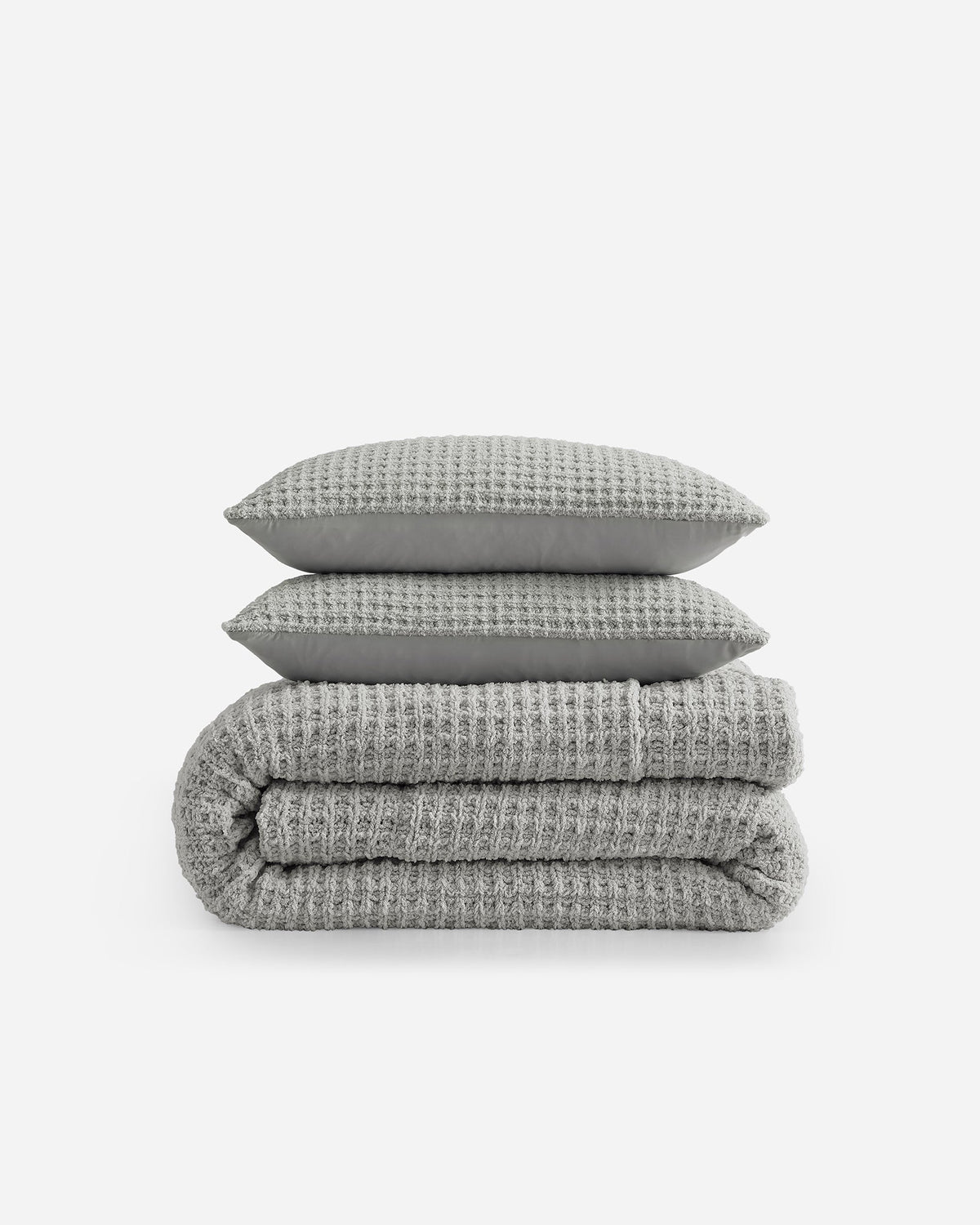 Cloud gray waffle bedding stack with textured surface and folded layers