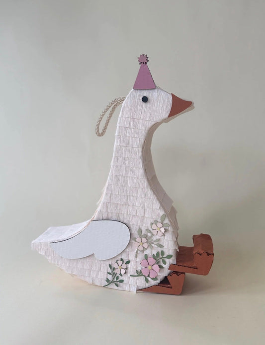 Sitting goose piñata with pink party hat and floral details