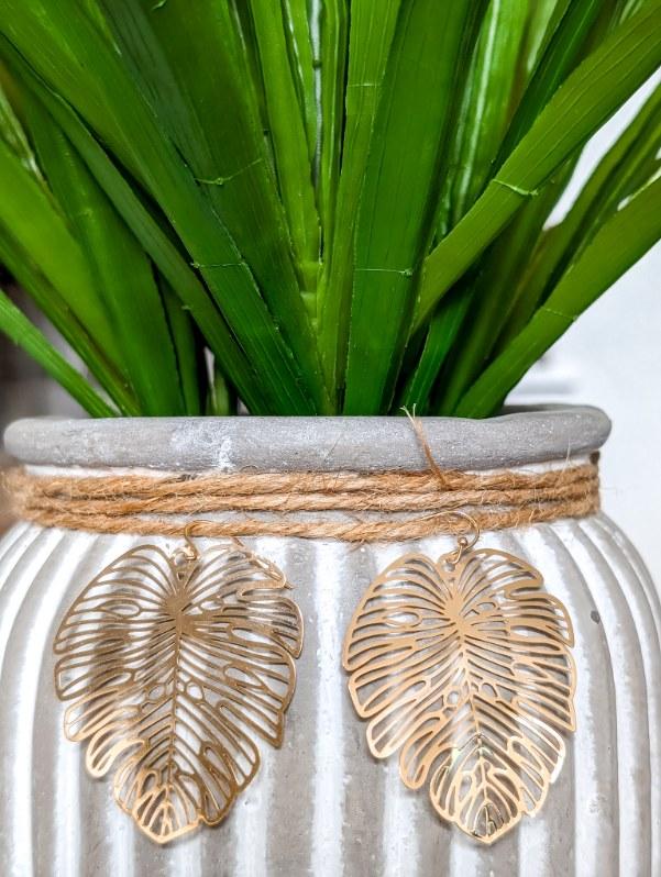 Gold leaf earrings with intricate cutout leaf pattern, hanging dangle style