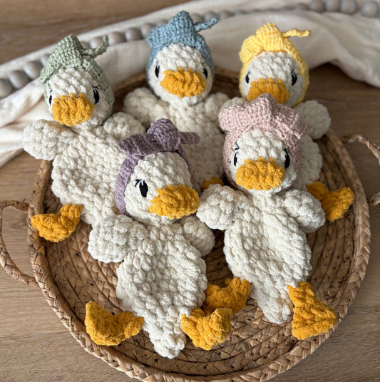 Crocheted baby duckling plush with yellow beak and gray body