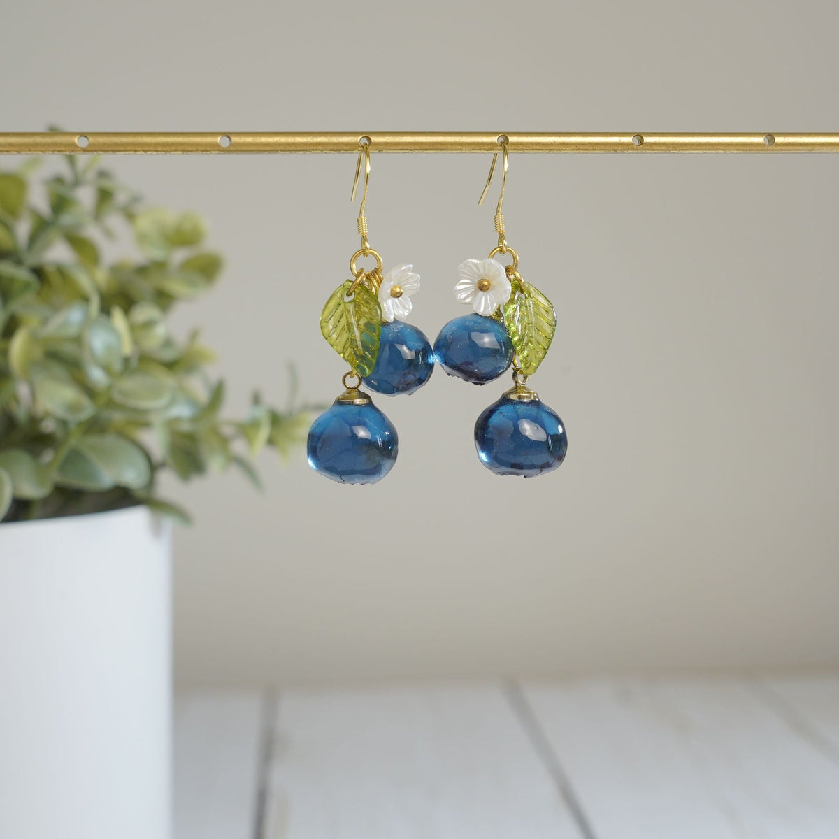 Blueberry cluster dangle earrings with blue resin berries, green leaves, white flowers, gold hooks