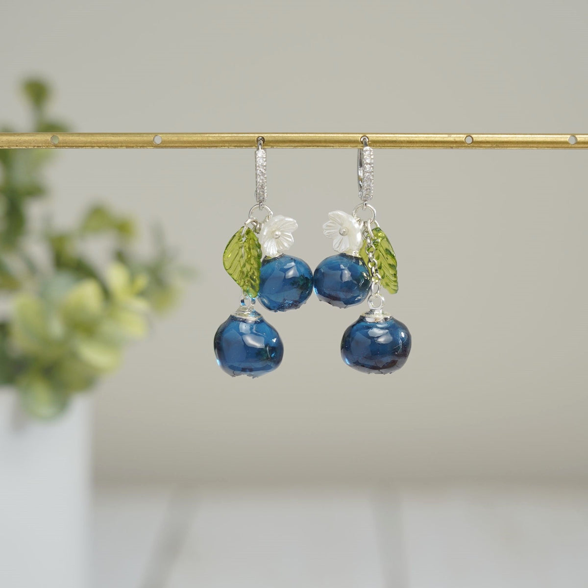 Blueberry cluster dangle earrings with blue resin berries, green leaves, white flowers, silver hooks