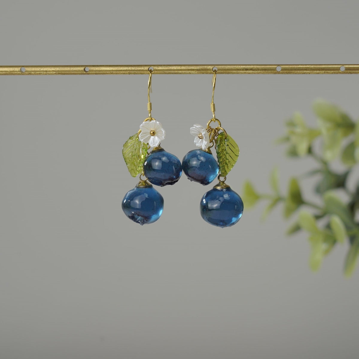 Blueberry cluster dangle earrings with blue resin berries, green leaves, white flowers, gold hooks