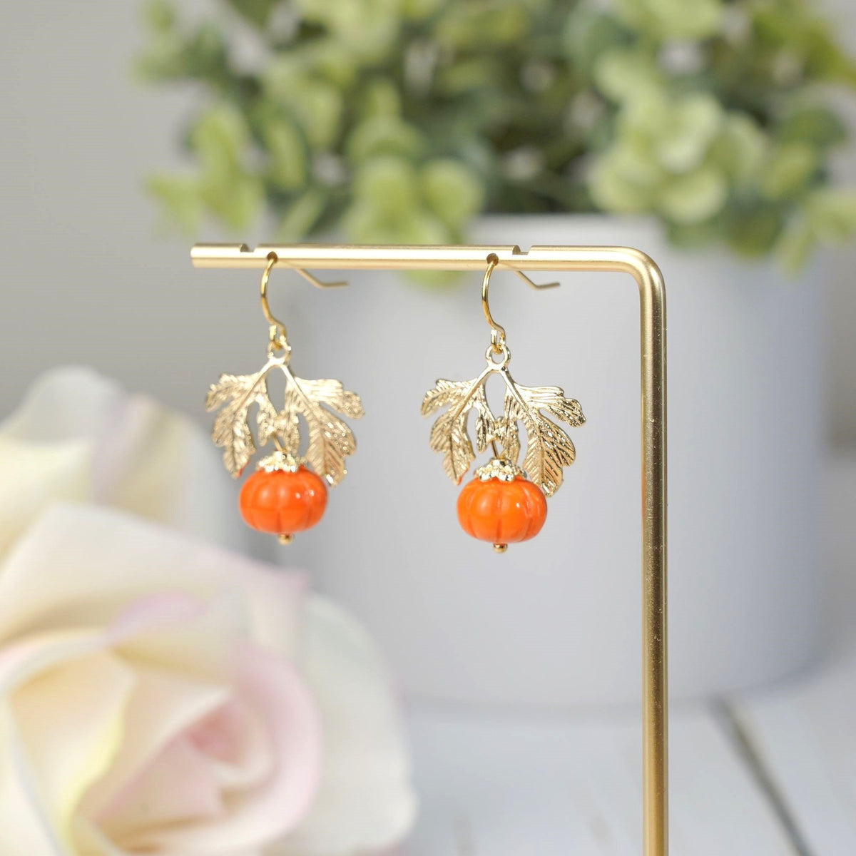 Gold-tone hanging pumpkin earrings with orange glass beads and leaf charms