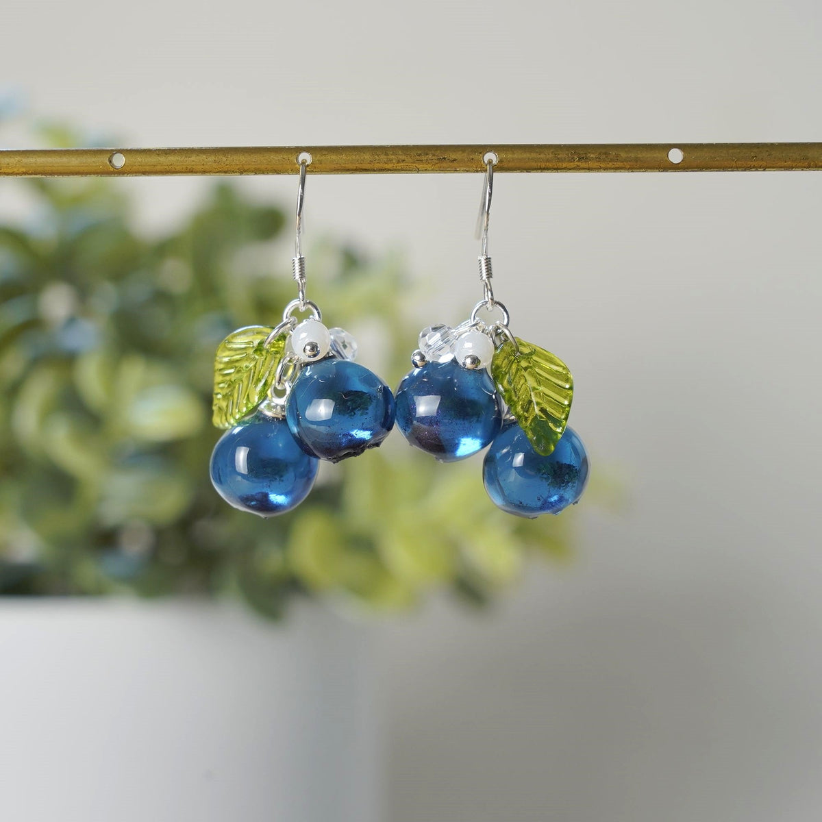 Blue resin cluster earrings with silver hooks, green leaf charms, dangling beads