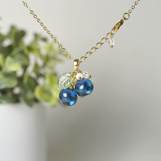 Gold blueberry fruit cluster necklace with resin berries, green leaves, and small bead drops