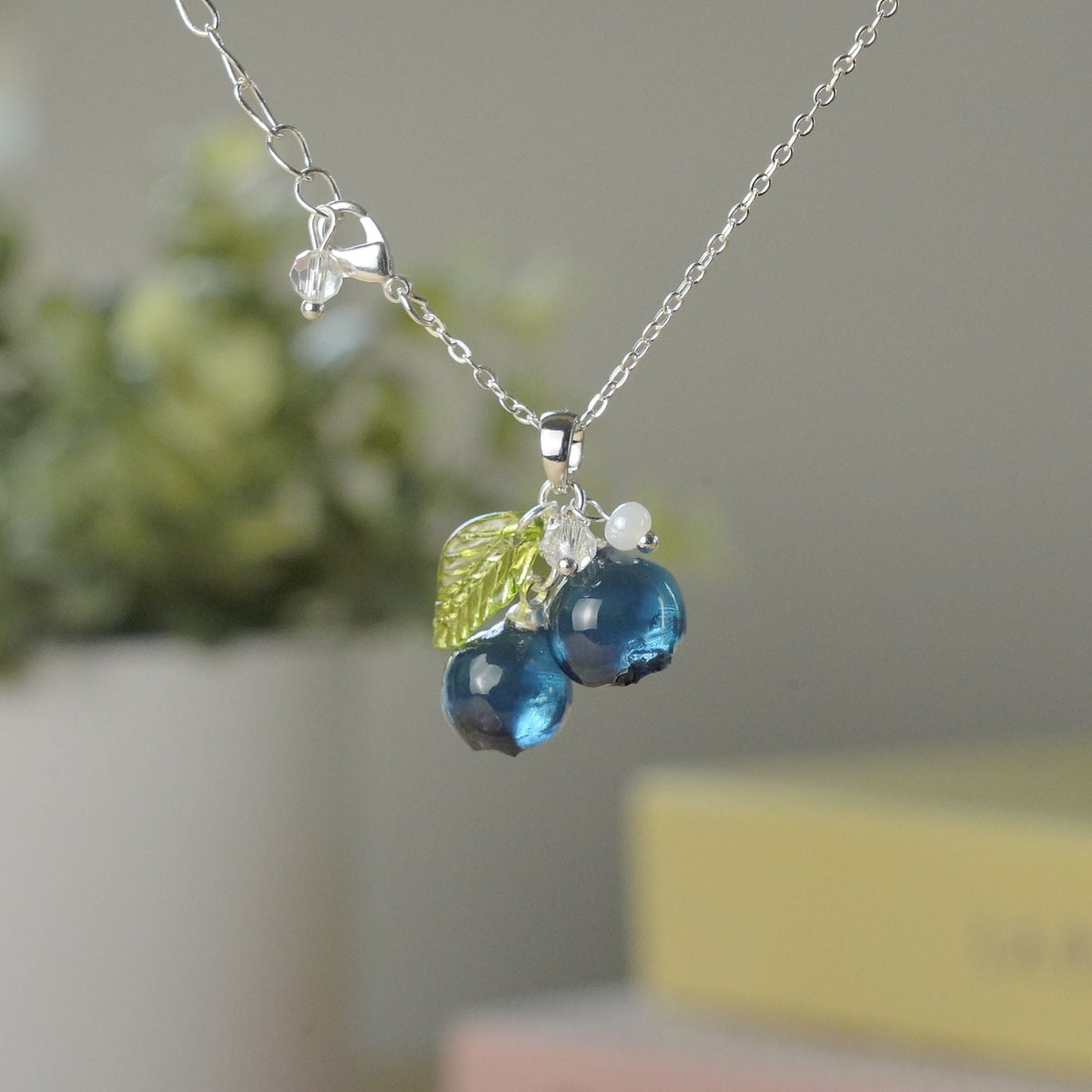 Silver blueberry fruit cluster necklace with resin berries, green leaves, and small bead drops