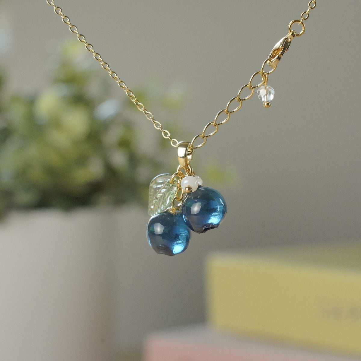 Gold blueberry fruit cluster pendant necklace with resin berries and green leaf charm