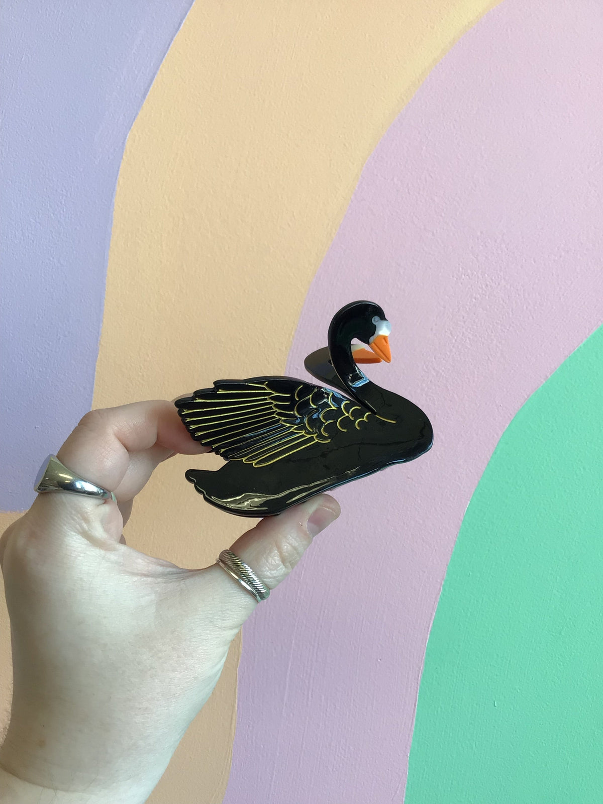 Black bird hair claw with orange beak, glossy cartoon layered feathers