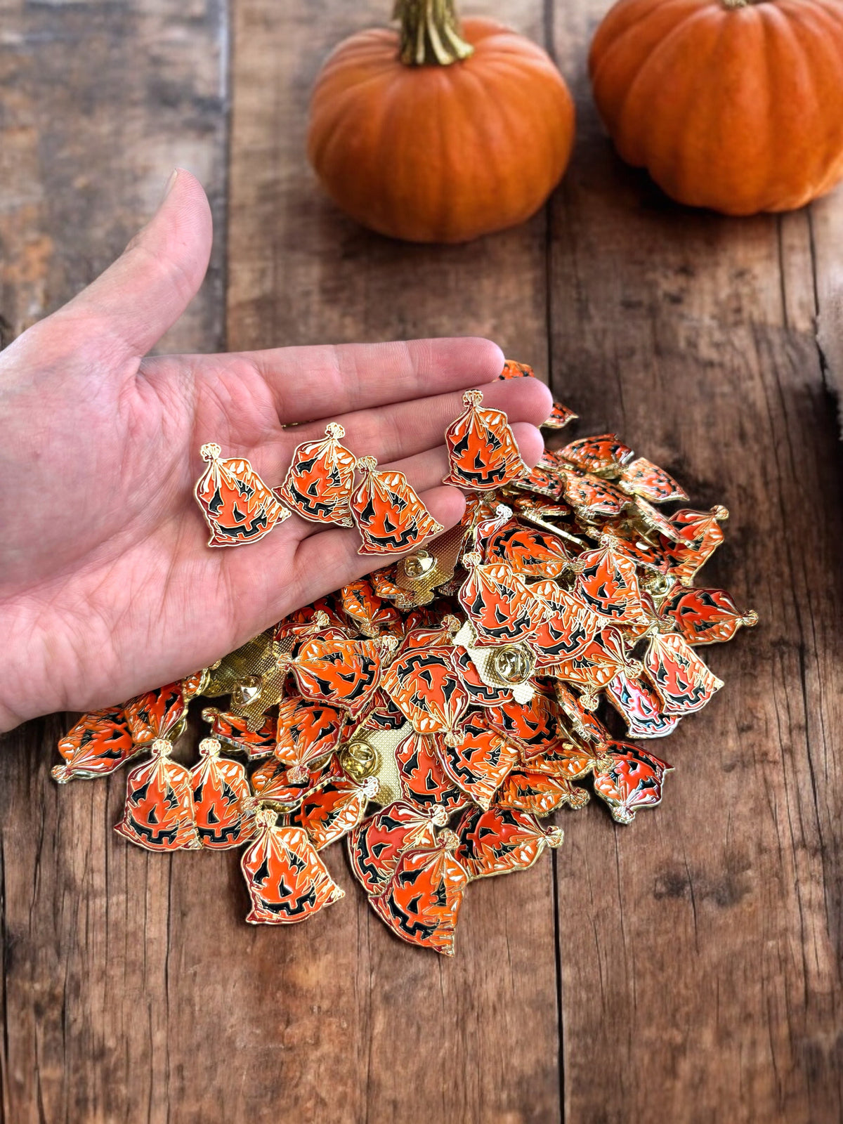 Set of enamel jack-o'-lantern leaf bag pins, orange pumpkin heads with black cutouts