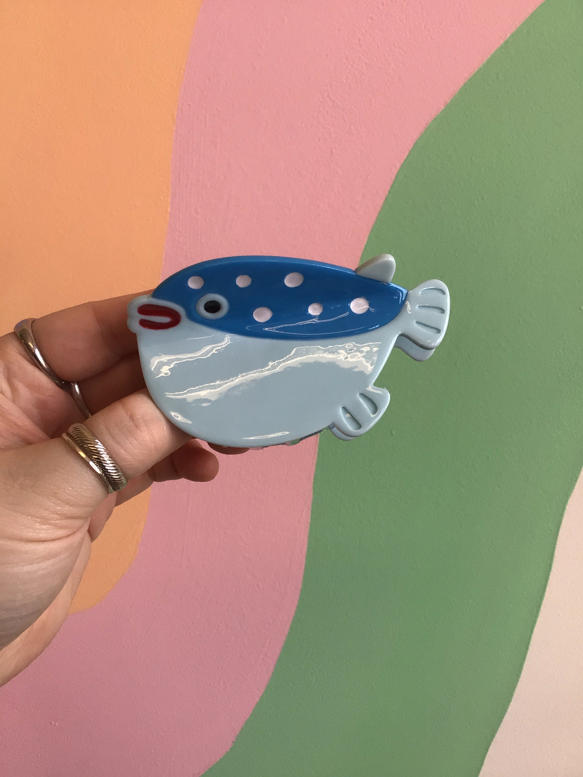 Blue fish-shaped hair claw with white wave lines and round dot pattern