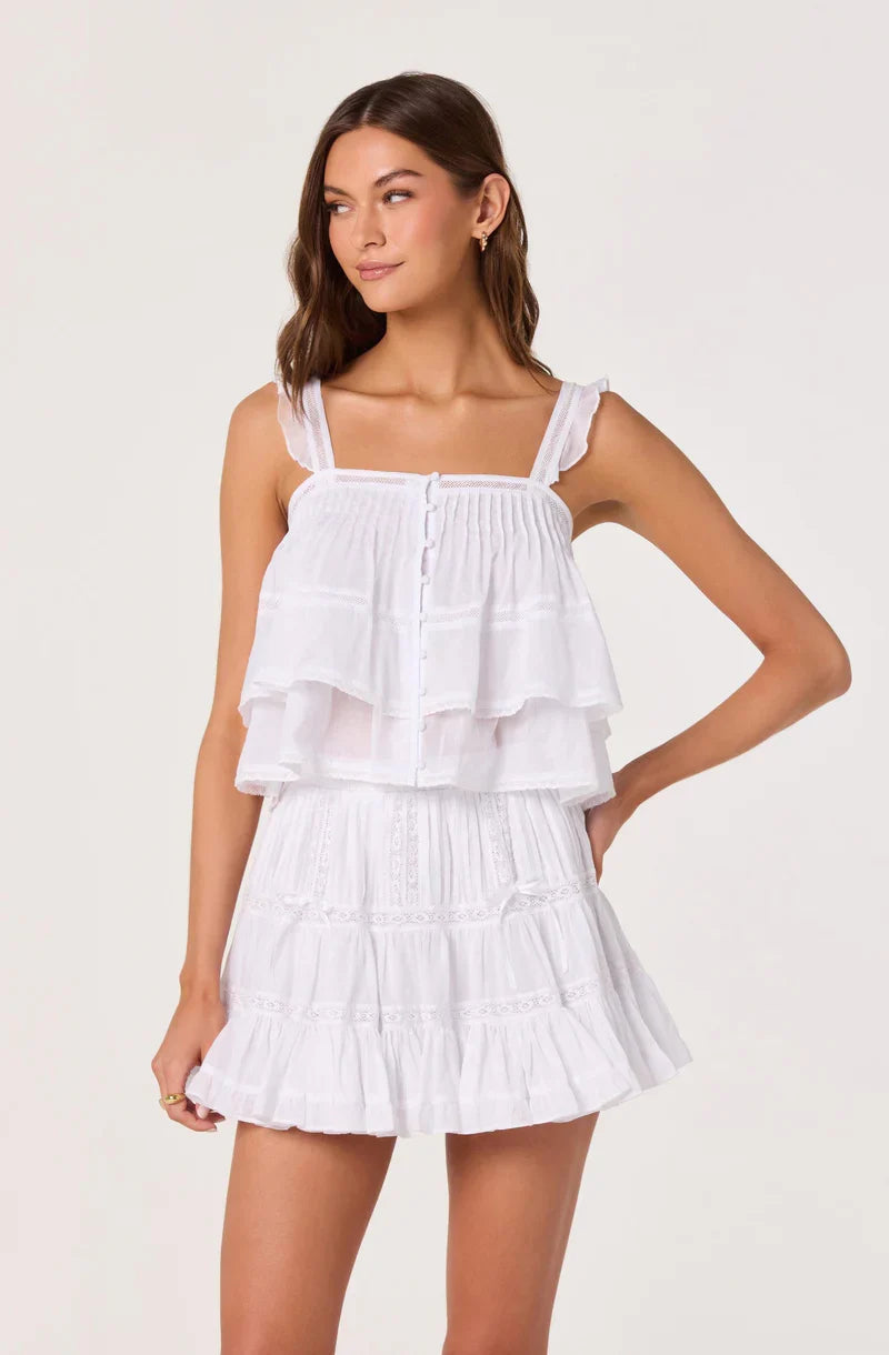 White tiered mini skirt featuring layered ruffles and elastic, smocked waistband.