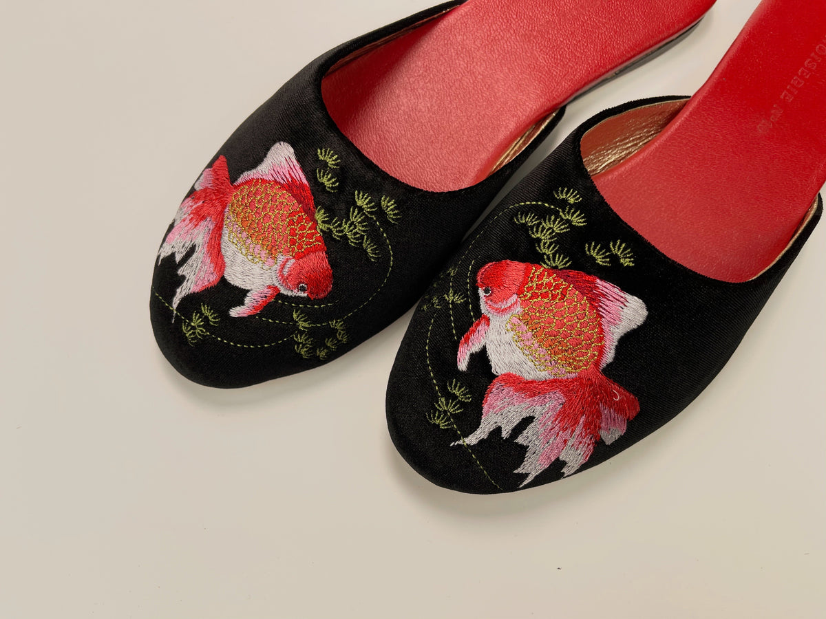 Black velvet mule slippers with goldfish embroidery and red curved heel area