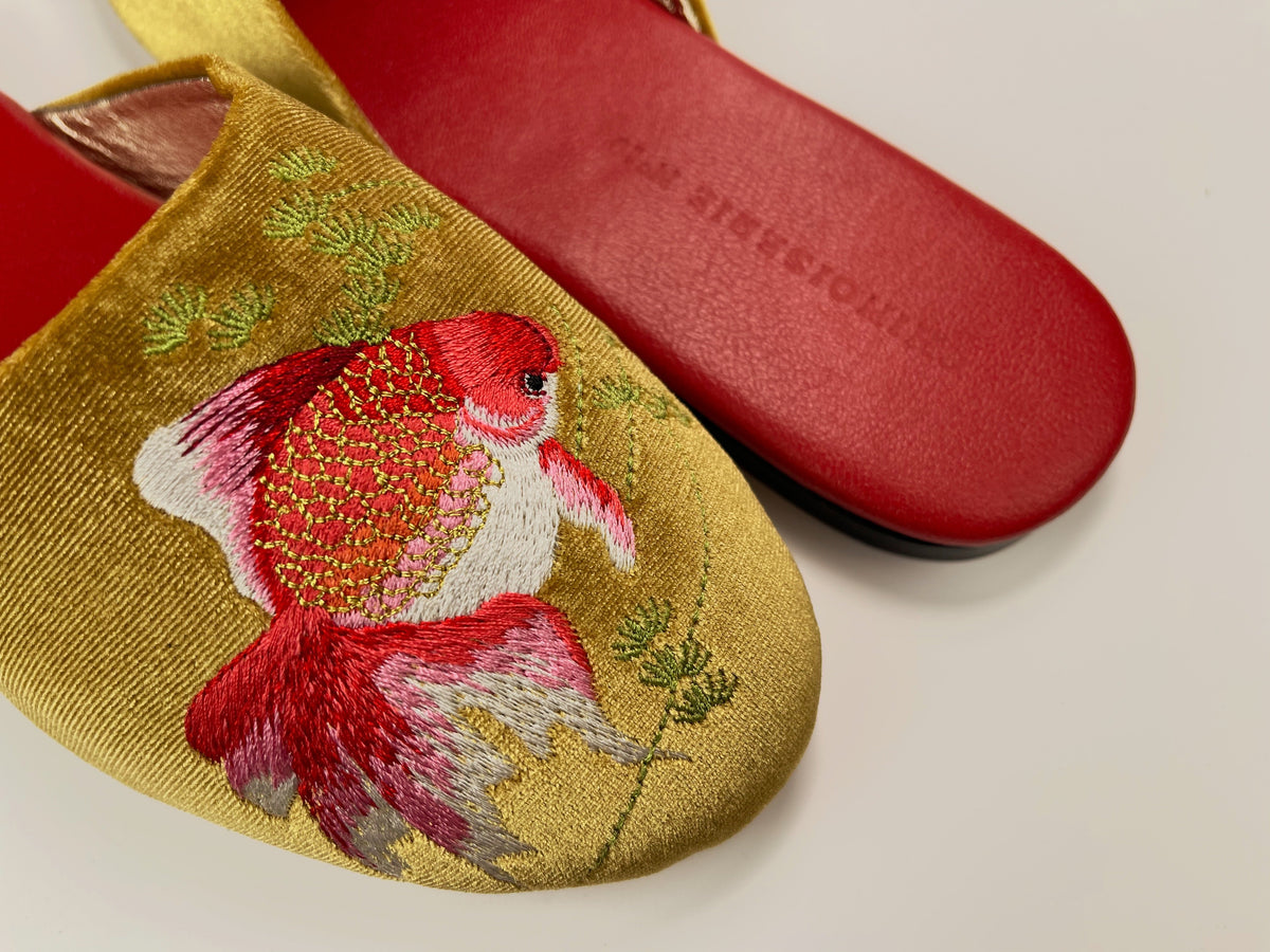 Gold velvet mule slipper close-up: red and white goldfish embroidery, red sole