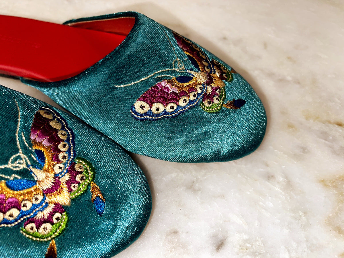 Teal velvet mule slippers with embroidered butterfly detail and red lining