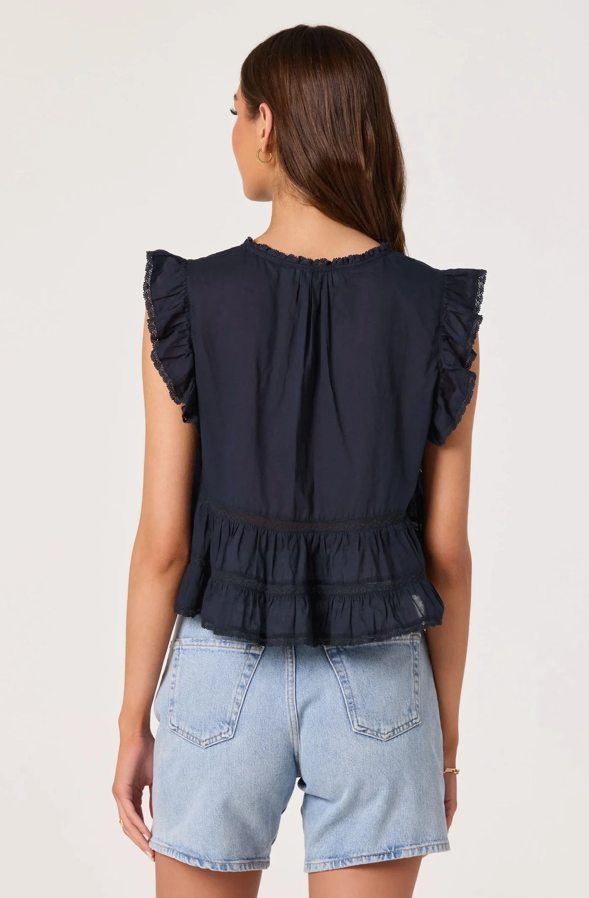 Navy sleeveless top back view with ruffled shoulders and gathered tiered waist