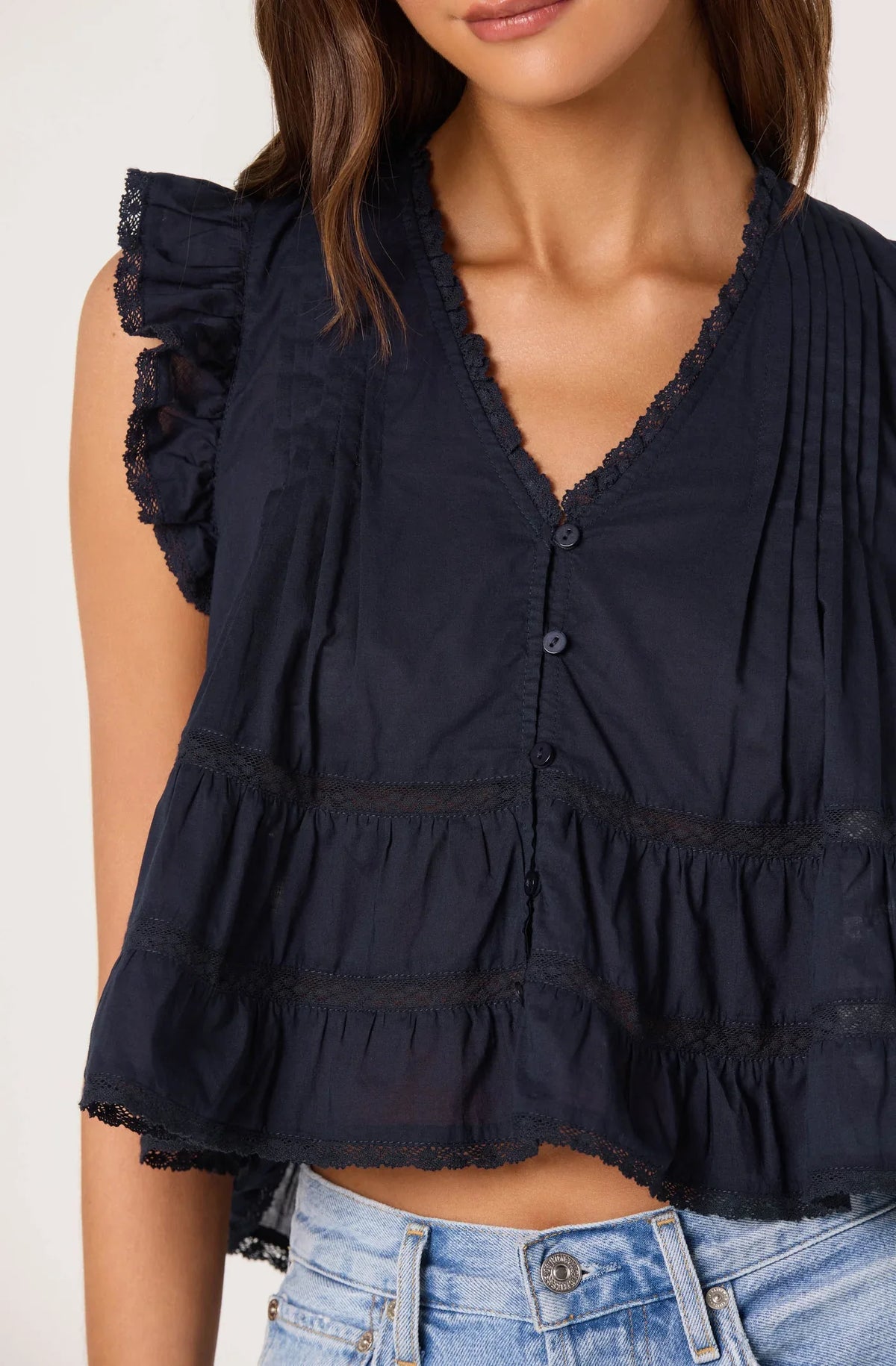 Navy V-neck button front sleeveless top with pintucks and tiered ruffle hem