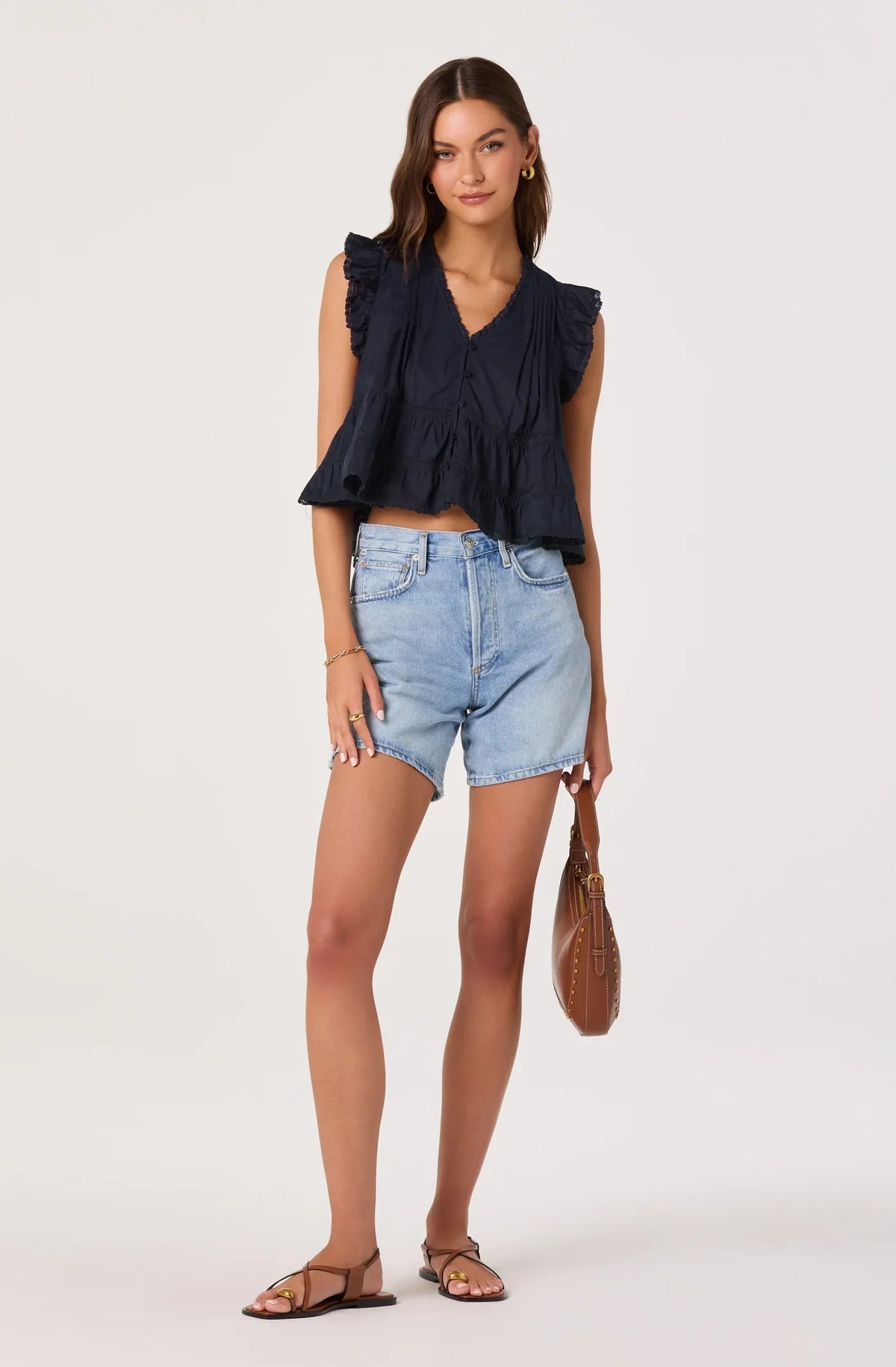 Navy sleeveless ruffle top with V-neck buttons and tiered hem