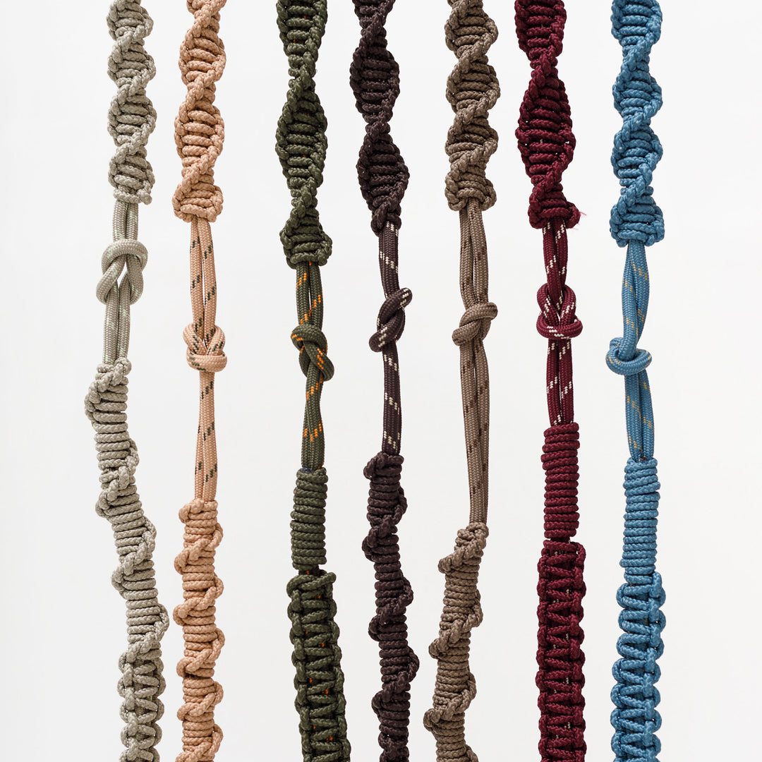 Macrame bag straps hanging with metal clips; braided cords in several colors
