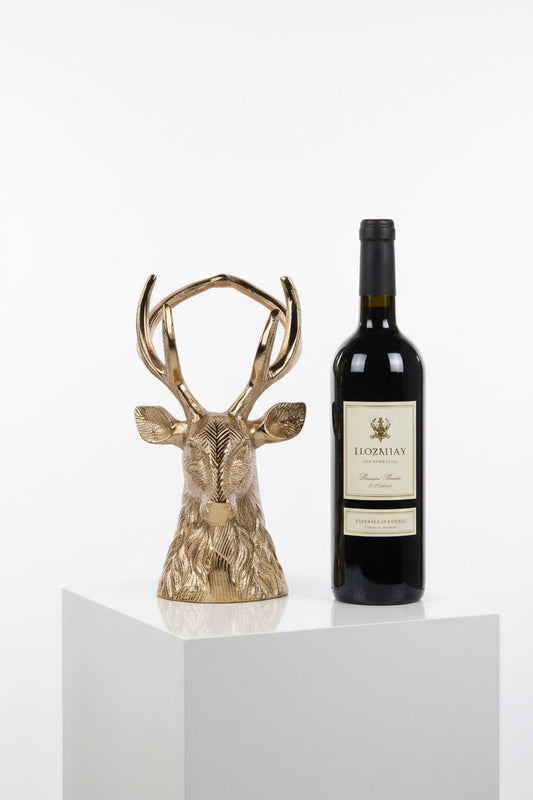 Gold-tone deer head wine bottle holder with tall antlers, shown beside a wine bottle