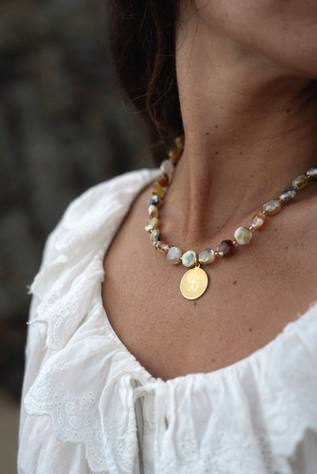 Agate beaded necklace with round gold initial pendant, mixed white and amber beads