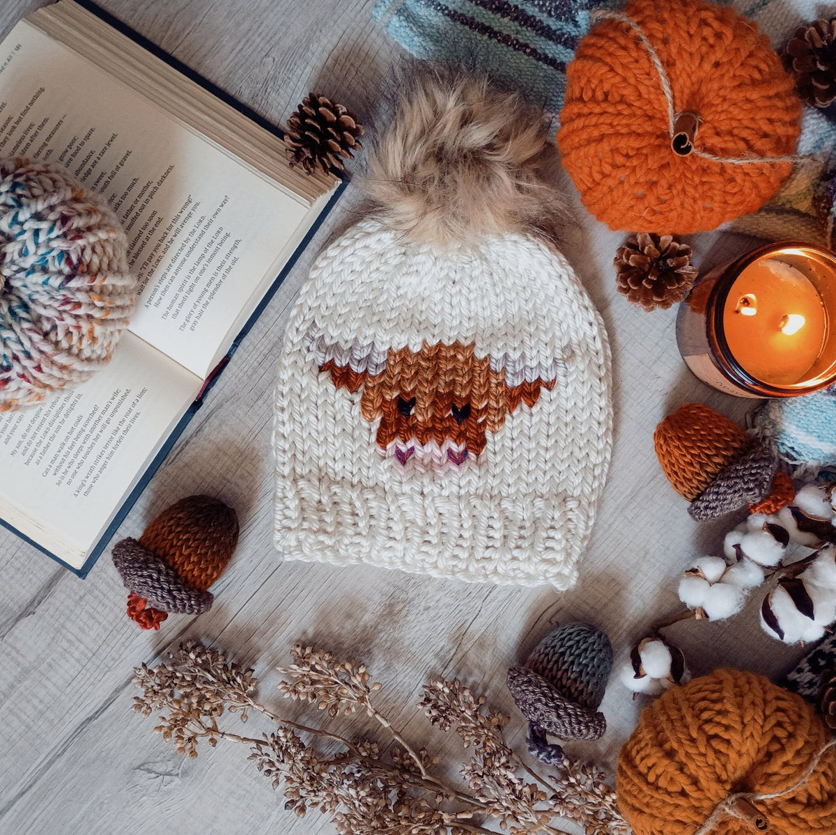 Cream knit beanie with faux-fur pom-pom and brown-and-cream cow motif