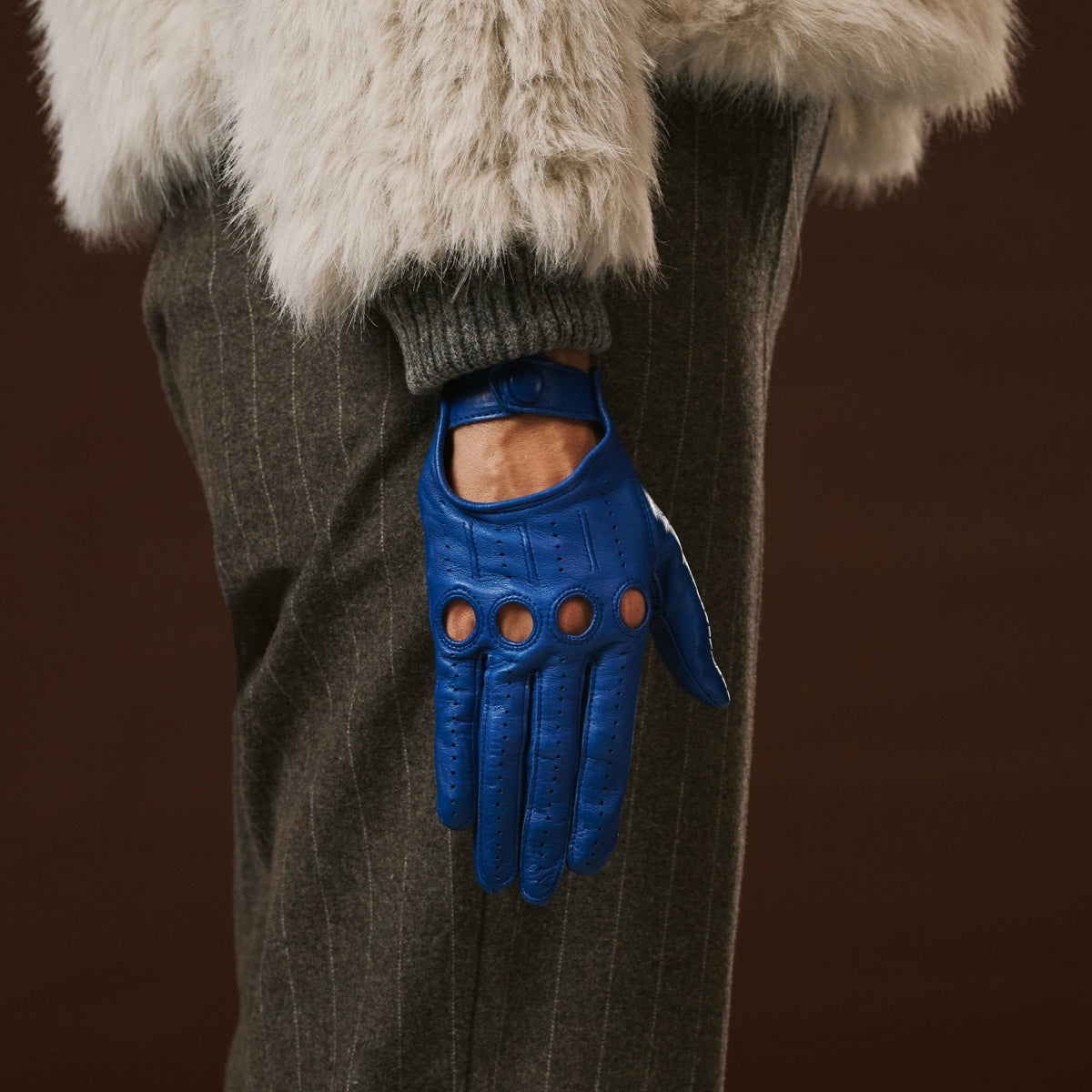 Blue leather driving glove with circular cutouts and finger ventilation