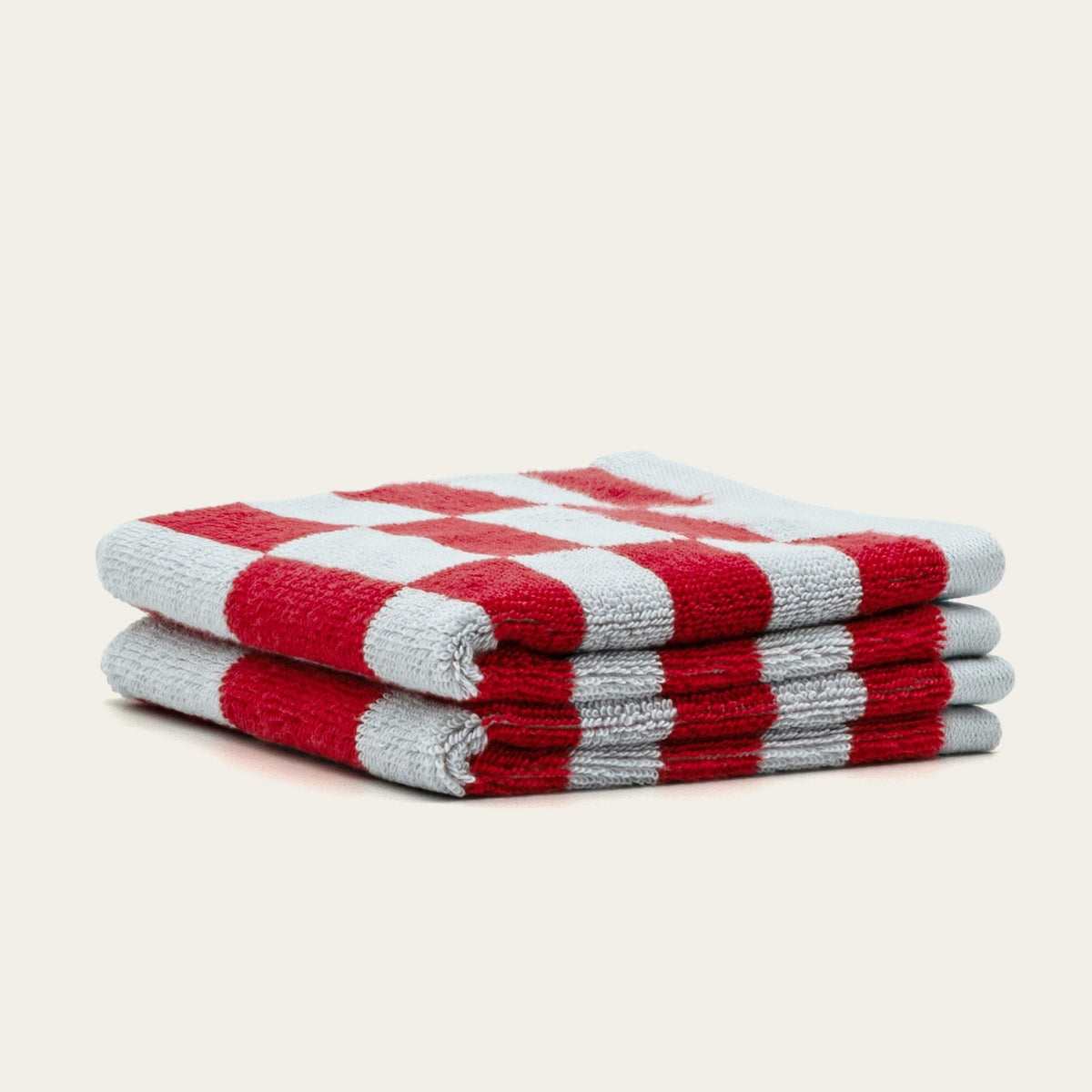 Stack of red and white check cotton towels, folded with soft textured weave