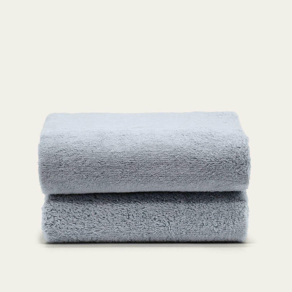 Light blue cotton towels, neatly folded stack with plush texture