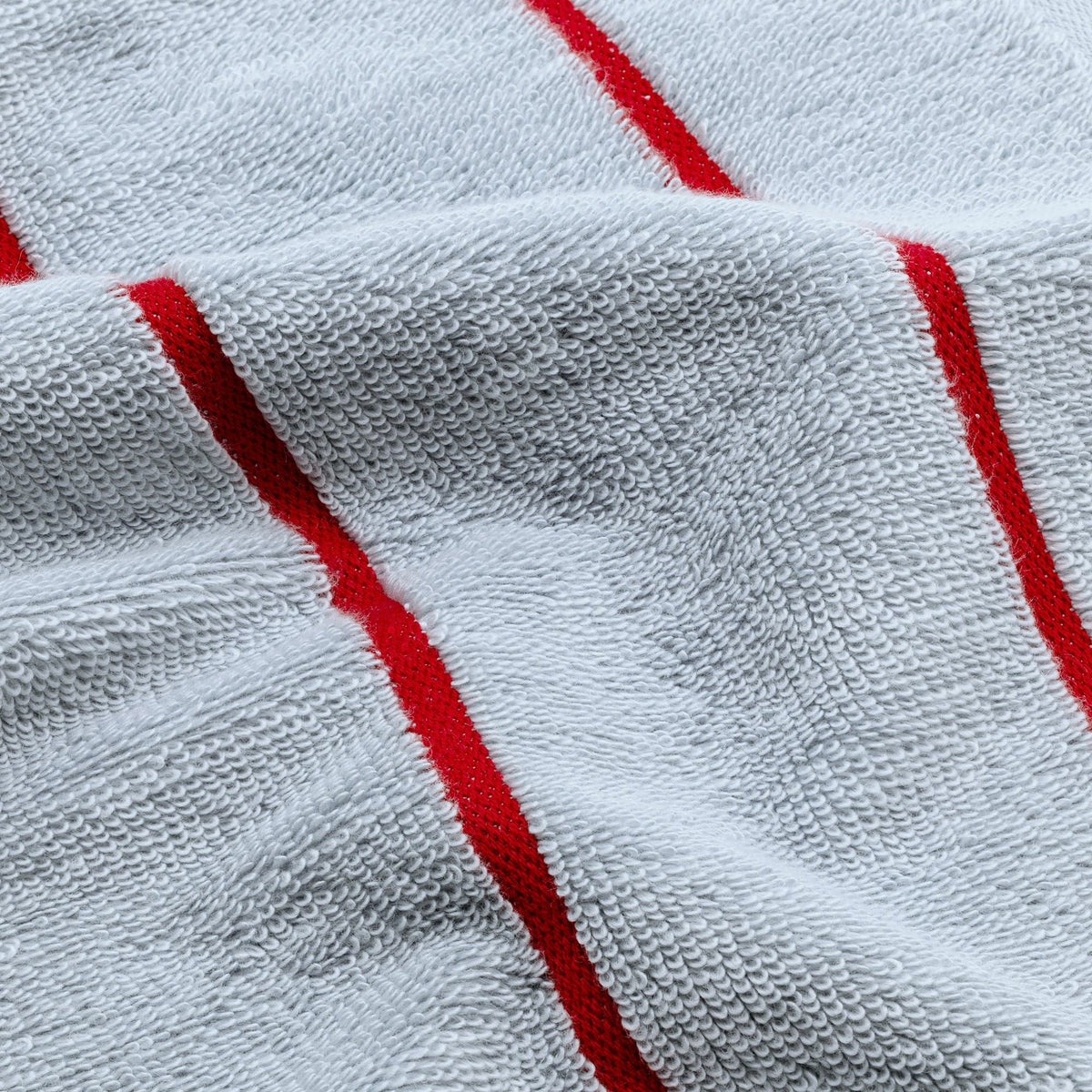 Light blue cotton towel fabric close-up with red stripe accents