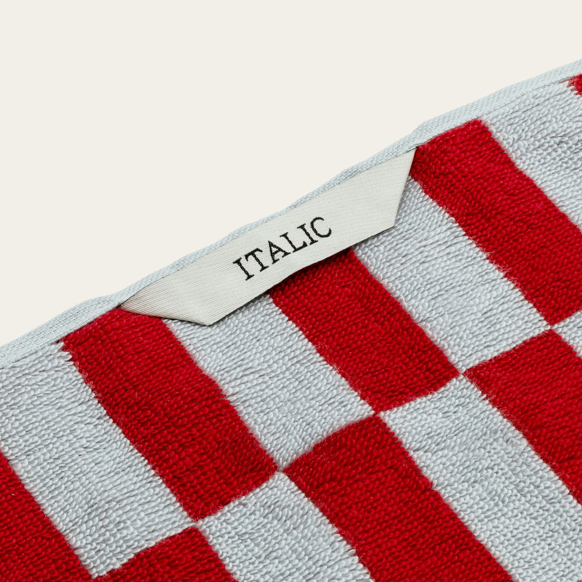 Red and white checked cotton towel with woven tag label on the edge