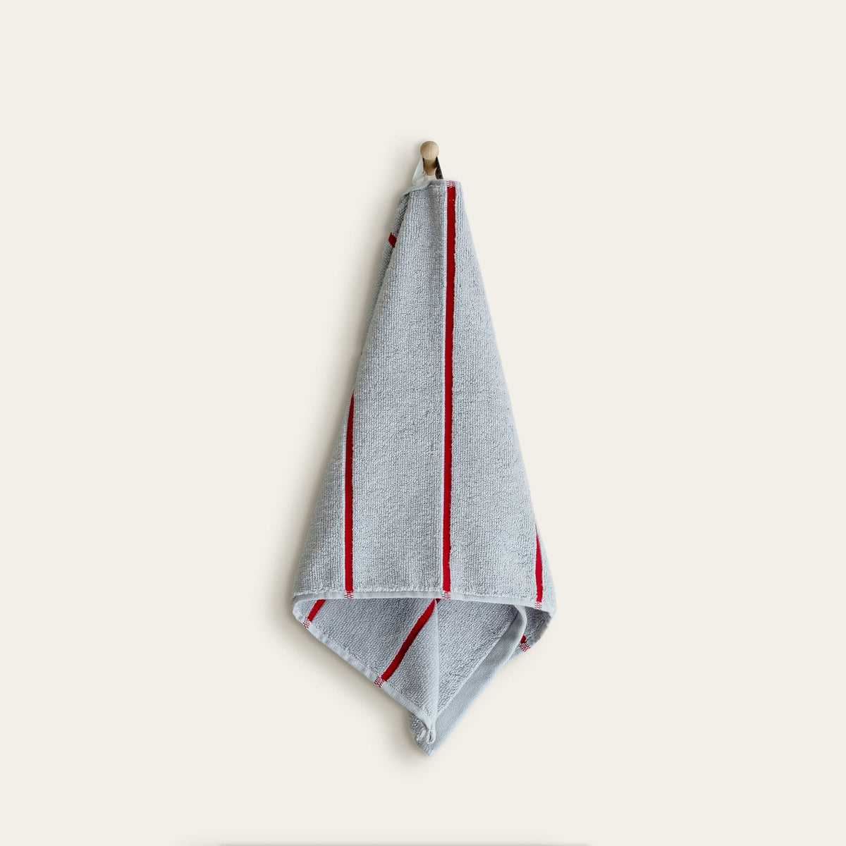 Light blue hand towel with bold red vertical stripes and stitched hem