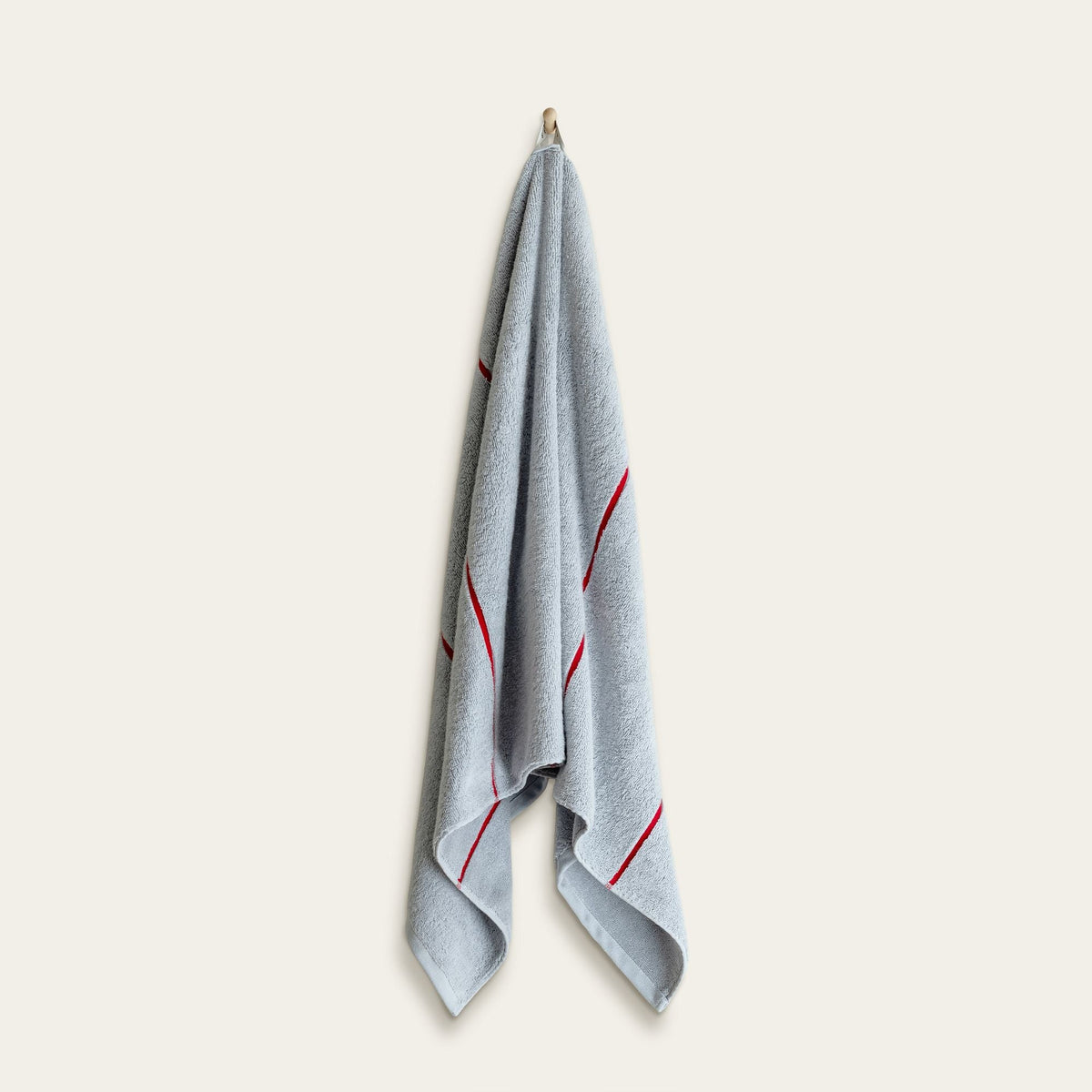Light blue hand towel with red stripe accents, folded and hanging