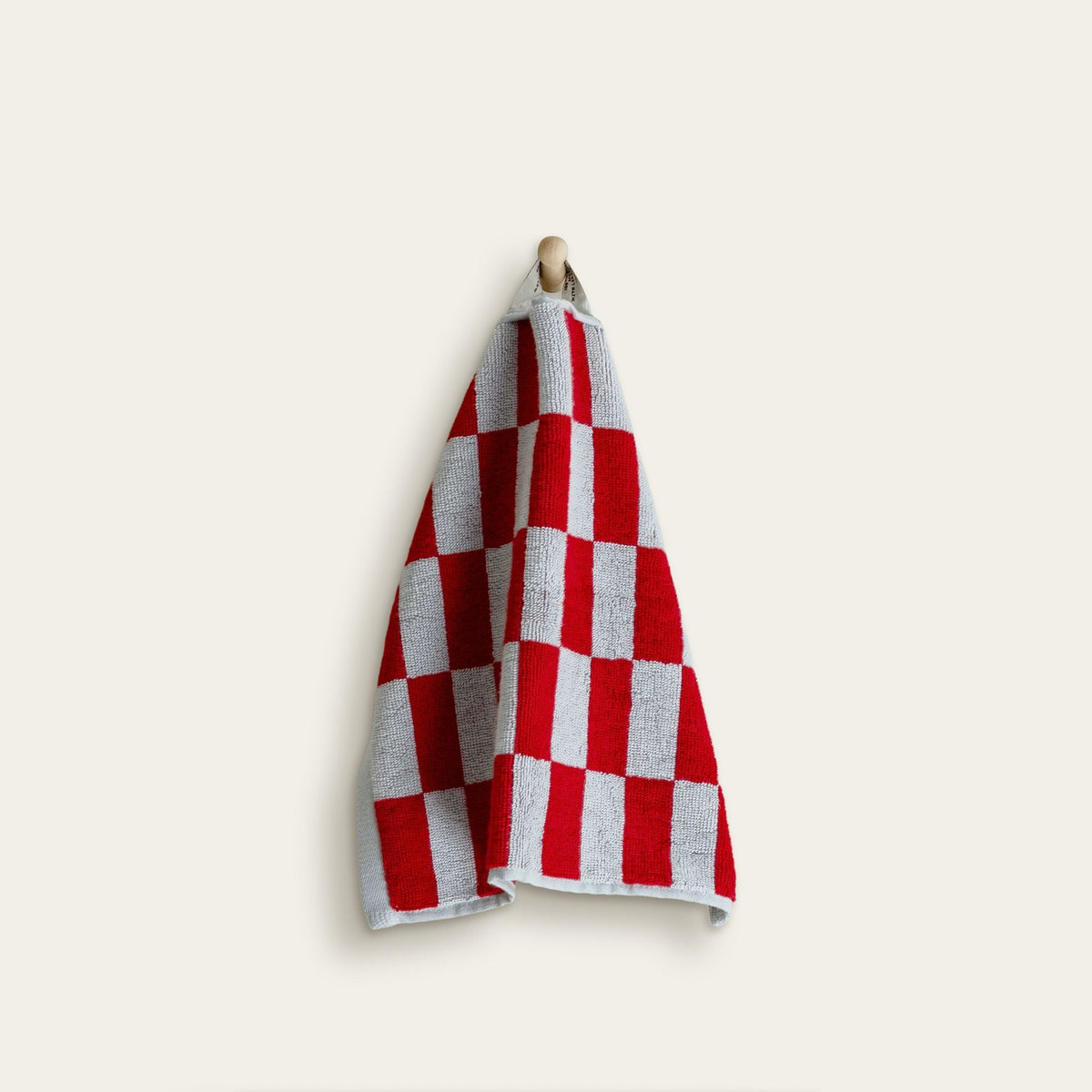 Red and white check cotton towel hanging with visible soft looped texture