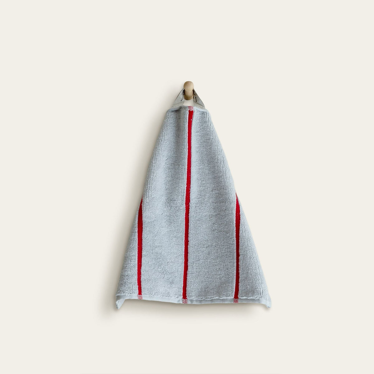 Light blue hand towel with red vertical stripes, folded and hanging