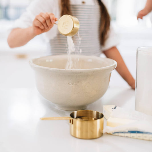 Cream stoneware mixing bowl with a wide rim, shown during baking