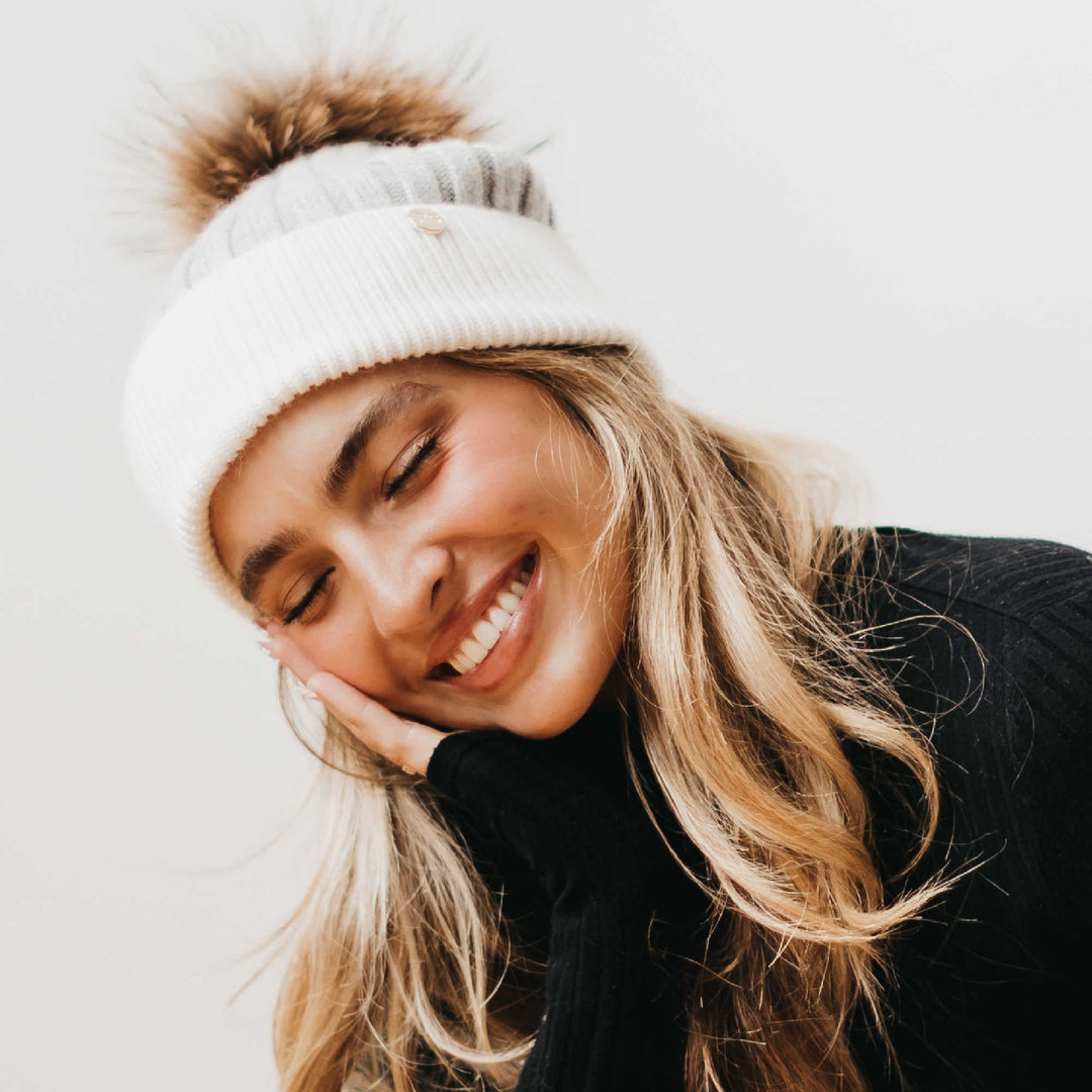 Two-tone angora knit beanie with tan fur pom; cream ribbed knit and cuff