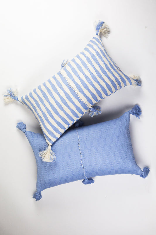 Light blue striped pillow with tassel corners, with solid blue pillow