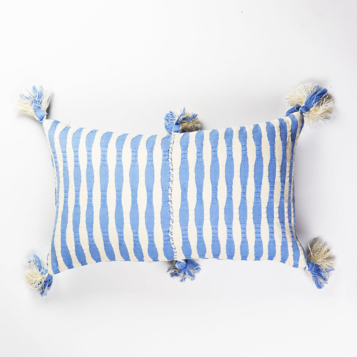Blue and white striped throw pillow with fringed tassels on corners