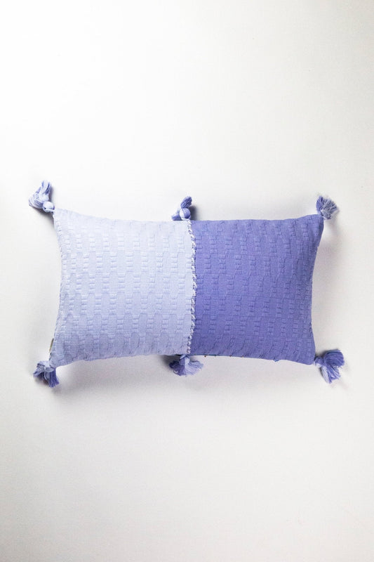 Periwinkle blue colorblocked decorative pillow with tassel corners.