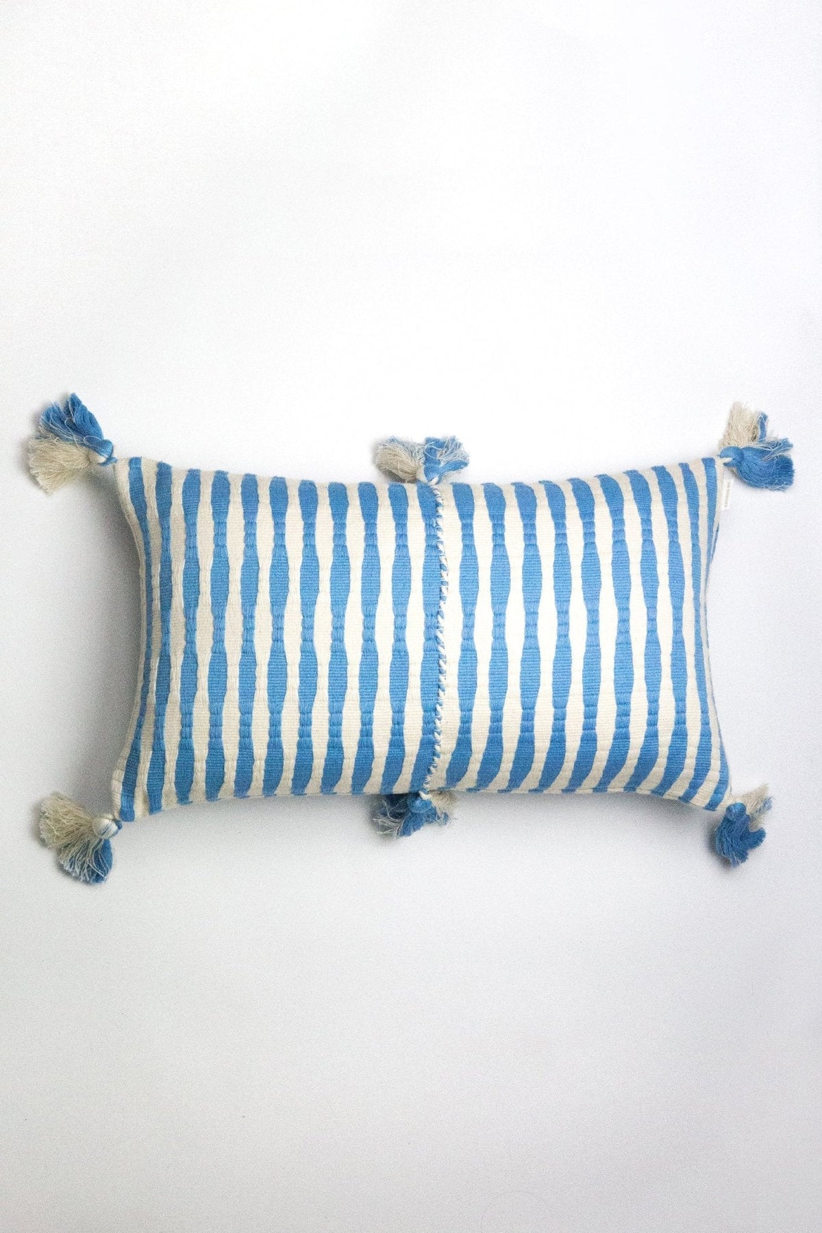 Sky blue striped lumbar pillow with pom tassels on the corners