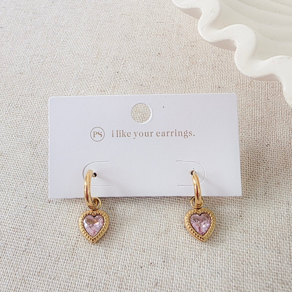 Gold-tone heart dangle earrings pair with pink heart charms on card