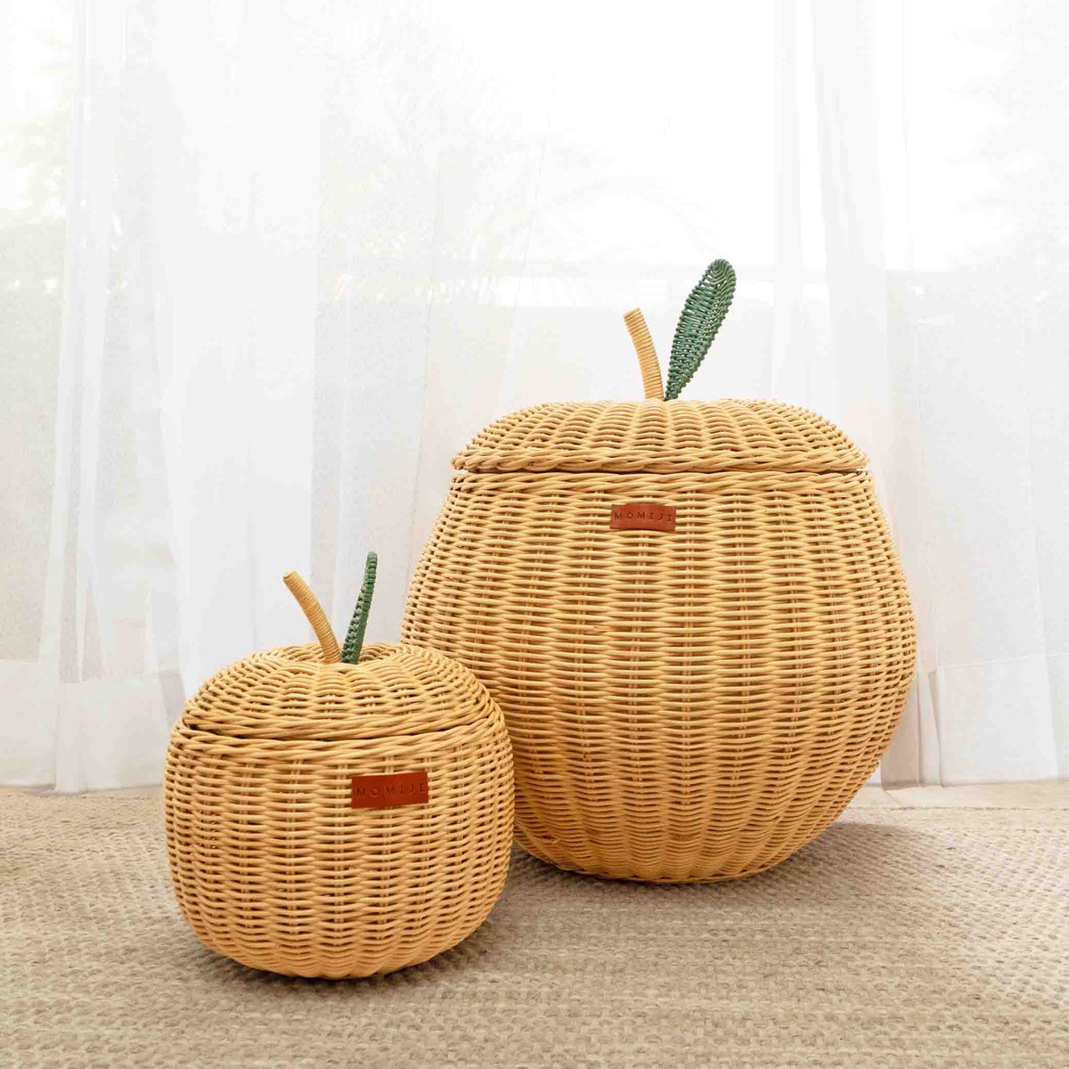 Small natural rattan apple basket with fitted lid and woven stem details beside a larger basket