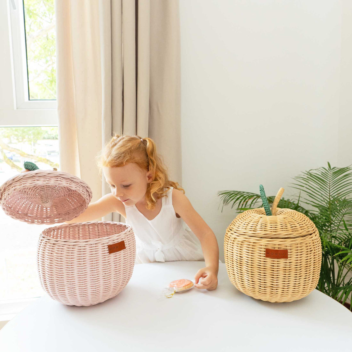 Natural rattan apple basket with fitted lid and woven stem details beside an open basket