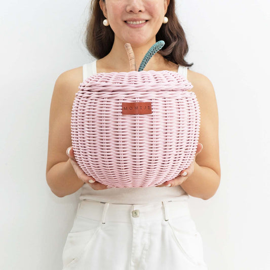 Small pink apple-shaped rattan storage basket with woven stem and leaf details