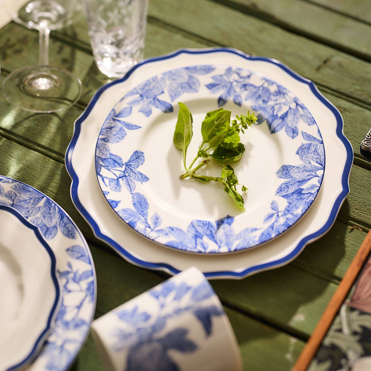 Blue botanical rim porcelain plate with white center, topped with salad greens