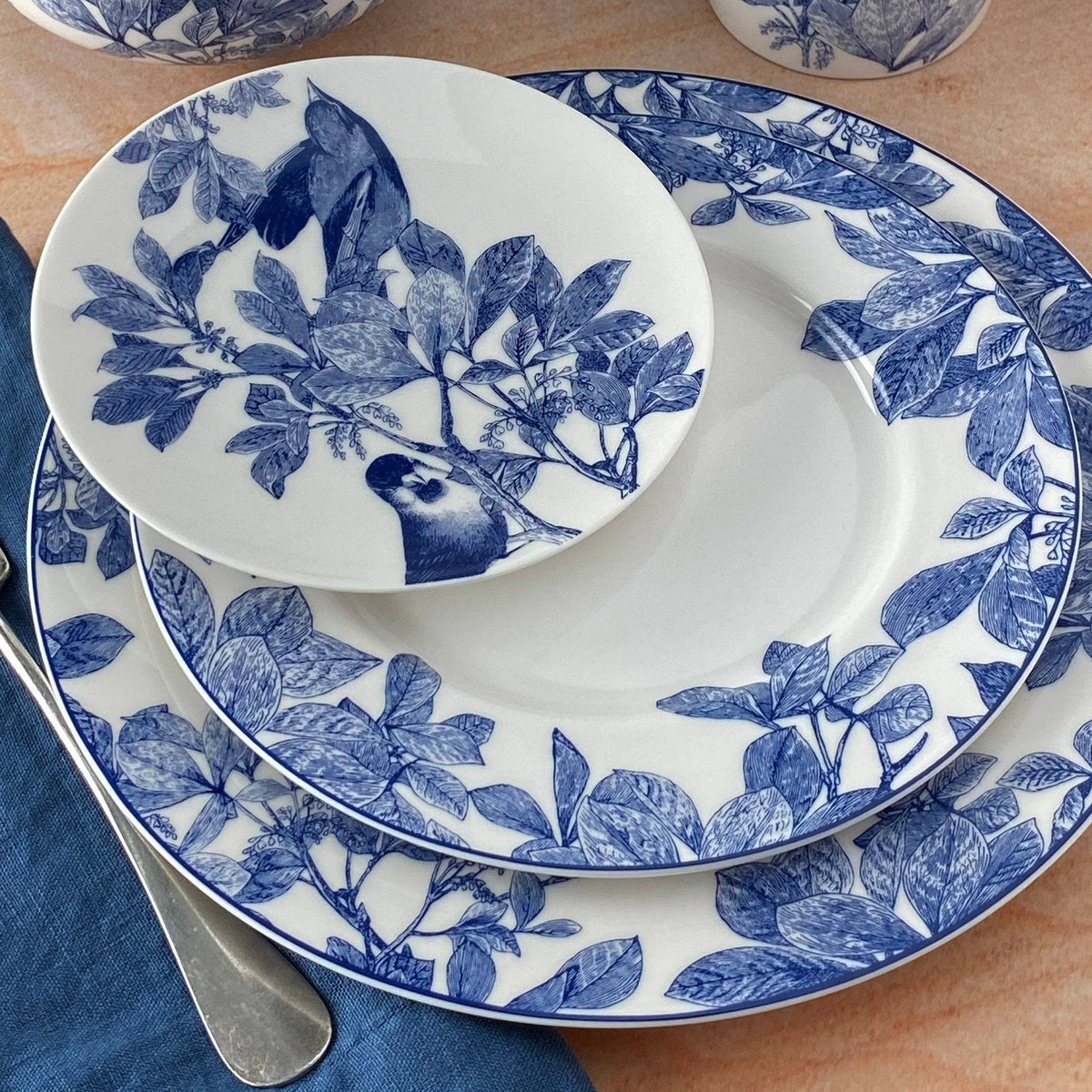 Porcelain serving plate with blue floral bird-and-leaf motif and botanical border rim
